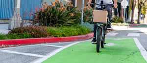 Rider on a CERO One biking in a green bike lane with a cardboard box on the front platform