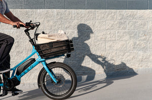 Rider on a blue CERO One biking up a steep hill with cargo