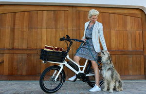 Rider sitting on a CERO One bike with a Small Basket in the front, petting a dog sitting next to the bike